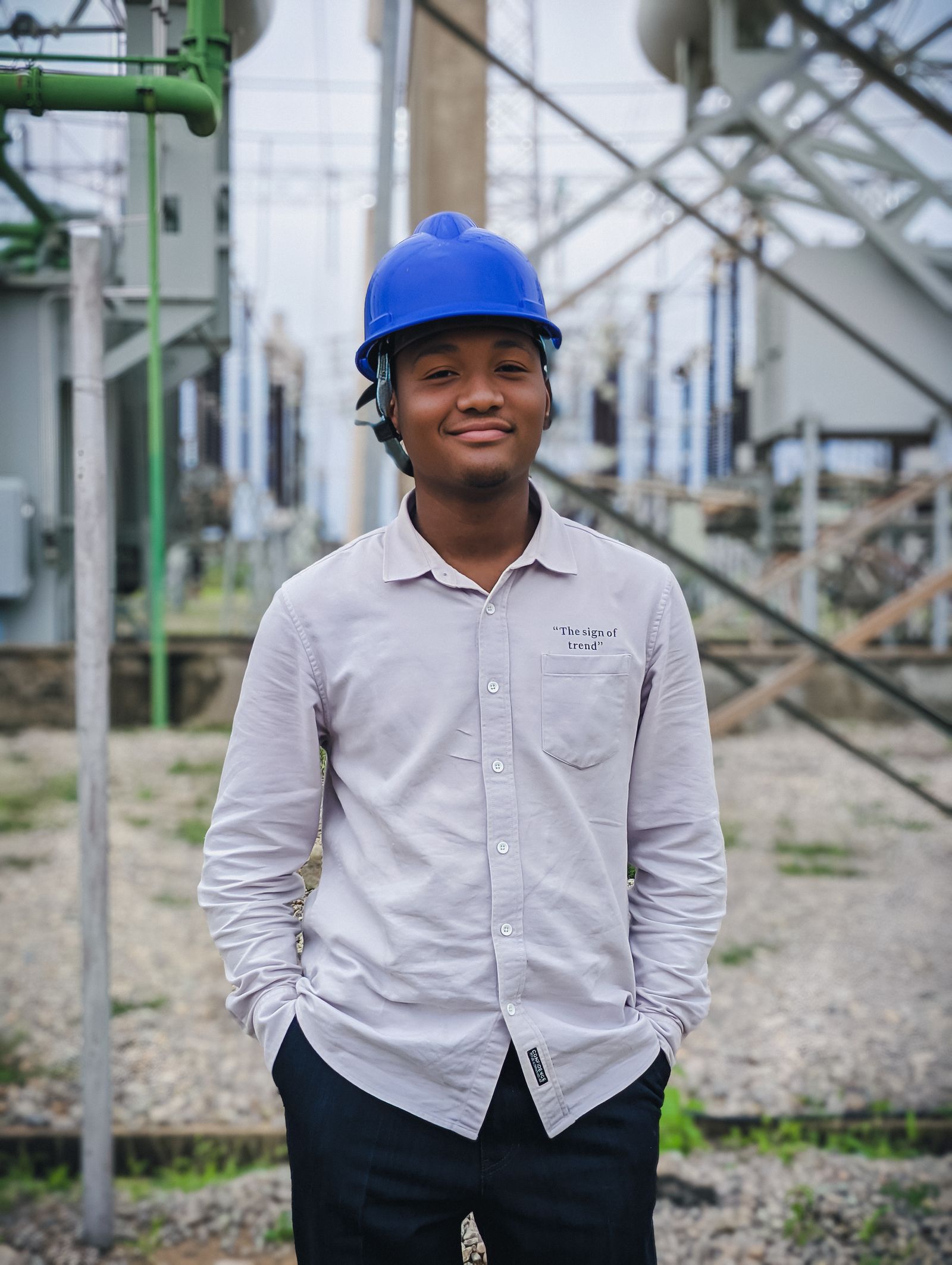 Engineer wearing a hard hat in front of a substation